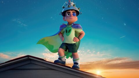 Elio, hlavní postava animovaného filmu Pixaru, stojí v superhrdinské póze na střeše domu v charakteristické helmě a plášti