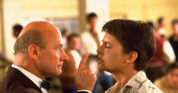 James Tolkan jako ředitel Strickland v rozhovoru s Michaelem J. Foxem ve filmu Návrat do budoucnosti