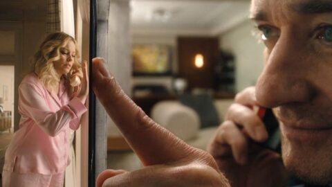 Elizabeth Banks jako miniaturizovaná manželka v růžovém oblečení interaguje s obřím mužem v seriálu The Miniature Wife