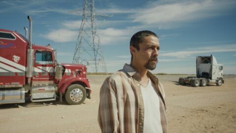 Hlavní postava filmu On The Road stojí na pouštní silnici u kamionu