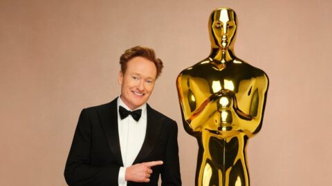 Conan O'Brien v smokingu s obří zlatou sochou Oscara