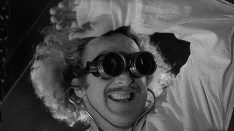 Gene Wilder jako Dr. Frederick Frankenstein s ochranými brýlemi a nadšeným výrazem ve filmu Young Frankenstein