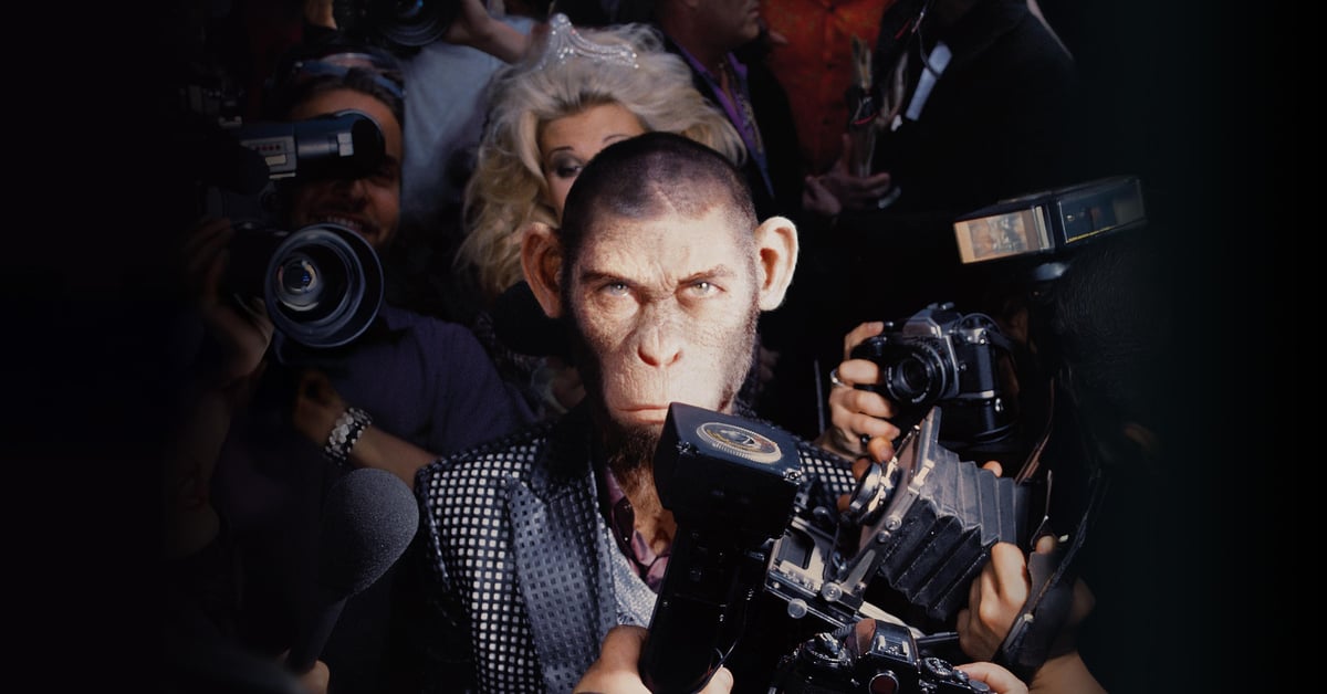 CGI opice představující Robbieho Williamse obklopená fotografy a novináři ve filmu Better Man