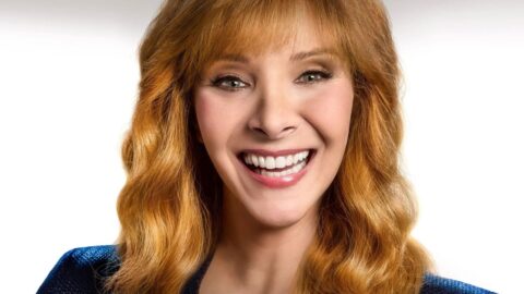 Lisa Kudrow se směje do kamery v modré bundě