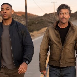 Aaron Pierre a Kyle Chandler jako John Stewart a Hal Jordan kráčí spolu po silnici v seriálu Lanterns