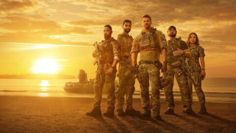 Herci seriálu SEAL Team v čele s Davidem Boreanazem na pláži při západu slunce