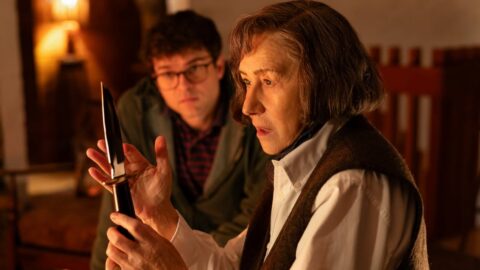 Helen Mirren jako spisovatelka Patricia Highsmith drží nůž ve filmu A Talent for Murder, v pozadí Alden Ehrenreich