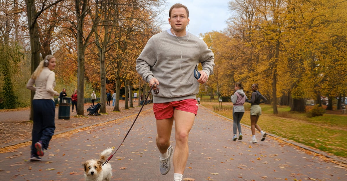 Taron Egerton běží v parku se psem, zatímco si ho všímají ženy ve filmu Everybody Wants to F--- Me