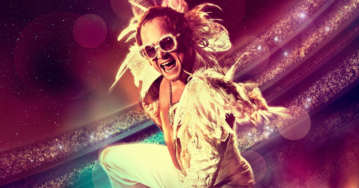 Taron Egerton jako Elton John ve filmu Rocketman, rozesmátý na koncertním pódiu v peřím kostýmu
