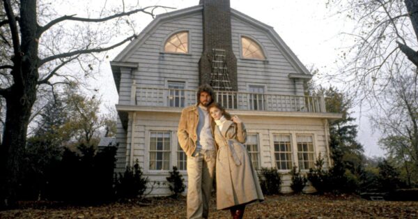 Dům v Amityville z filmu Hrůza v Amityville (1979) s hlavními postavami Lutzových před vchodem