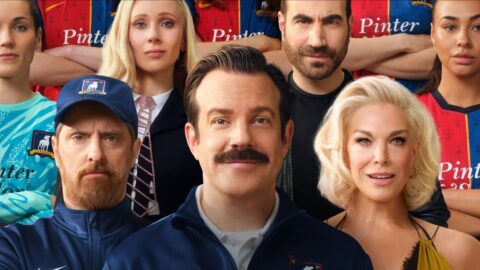 Jason Sudeikis jako Ted Lasso obklopený hlavními postavami seriálu Ted Lasso