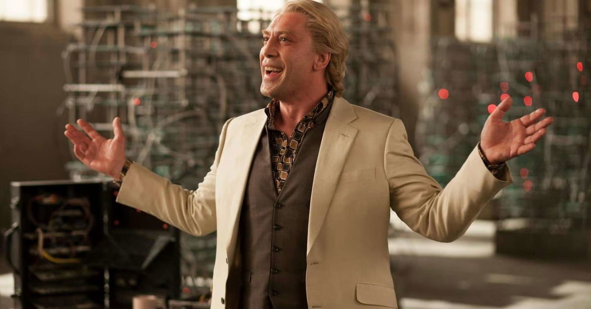 Javier Bardem jako zaporak Silva ve filmu Skyfall, usmivajici se s roztazenyma rukama v osvetlene hale