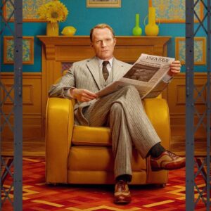 Paul Bettany jako Vision sedí v křesle a čte noviny s titulkem Vision Today v barevném interiéru ze seriálu VisionQuest