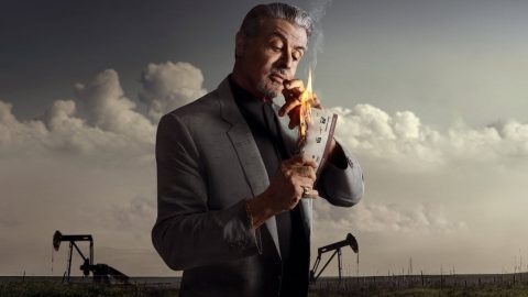 Sylvester Stallone jako Dwight Manfredi v seriálu Tulsa King pálí lístek na pozadí ropných čerpadel a oblačné oblohy