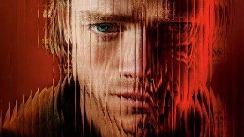 Zblízka tvář muže, jejíž pravá polovina se v červeném světle rozpíjí do deformované hmoty – promo obrázek k filmu Clayface